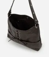 Cartera estilo hobo de cuero sintético en color gris oscuro, con diseño de media luna y correa fija para el hombro. Cuenta con bolsillos frontales funcionales, detalles de ojalillos metálicos plateados y un cordón cruzado ajustable con lazo en el centro.