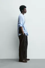 Pantalón de corte relajado confeccionado en una mezcla de algodón y lino. Presenta cintura elástica con cordón ajustable, bolsillos laterales y bolsillos traseros de vivo.