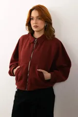 Buzo celeste de corte holgado, con cuello polo y cierre frontal parcial.