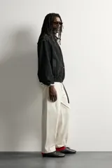 Cazadora de piel con acabado serraje de corte relaxed fit, color negro, con cuello solapa, bolsillos de vivo en la cadera, bajo elástico y cierre frontal con cremallera de doble dirección. Colección especial Aaron Levine x ZARA.