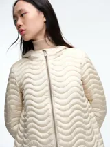 Campera negra con diseño acolchado de ondas horizontales, cierre frontal completo, capucha integrada y mangas largas.