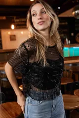 Top de red con brillo metalizado, de corte recto y manga corta. Presenta un diseño translúcido con acabado brillante, ideal para superponer sobre otras prendas.