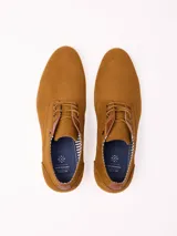 Zapato acordonado de estilo casual confeccionado en material sintético tipo gamuza color azul marino, con suela plana de goma en tono claro y detalles de cuero en el talón y la lengüeta.