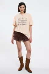 Remera de corte oversized en color blanco, con cuello redondo y mangas cortas. Presenta una estampa central con la frase 'Living a hot life' y un diseño de ajíes rojos.