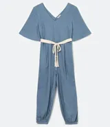 Mono largo celeste de viscosa y lino, con escote en V, mangas cortas amplias, pinzas en la cintura y cinto de cordón trenzado con borlas.