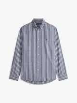 Camisa Tommy Hilfiger de corte regular, confeccionada en popelín de algodón azul con rayas verticales texturizadas. Presenta cuello camisero, cierre frontal de botones, mangas largas con puños abotonados y logo bordado en el pecho.