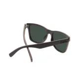 Lentes de sol Indie Forest con montura cuadrada de madera color ébano y lentes polarizadas verdes.