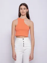 Top corto blanco de punto, sin mangas, con cuello halter asimétrico.