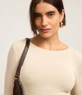 Suéter color crema de tricot con cuello redondo y manga larga.