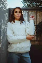 Sweater de lana merino color blanco, tejido a mano con textura tridimensional de flores en punto bodoque, cuello redondo a la base y mangas largas.