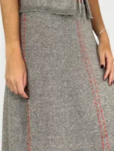 Pollera larga de tejido de lino color gris con costuras verticales rojas.