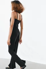 Pantalón de tiro alto confeccionado en crepe, con corte evasé y costuras frontales marcadas. Incluye un cinturón ajustable del mismo tejido con hebilla metálica y presenta cremalleras laterales ocultas en el bajo.