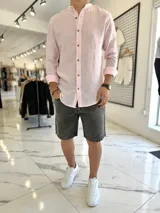 Camisa de lino con diseño de rayas verticales en tonos rosado y blanco, cuello mao y cierre frontal con botones.
