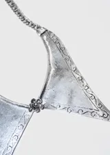 Collar dorado de aleación de metales con dije grande de forma triangular con puntas y flor al centro.