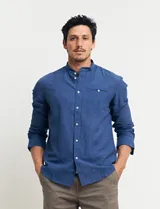 Camisa de cuello mao y manga larga, confeccionada en una mezcla de lino y algodón. Presenta un diseño de corte recto con botones en tono natural y un bolsillo pequeño en el pecho.