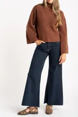 Polera de lana color marrón, con cuello alto, diseño acanalado y corte oversize con mangas anchas.