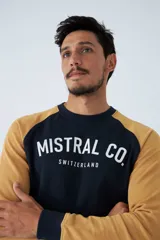 Buzo de cuello redondo con diseño de mangas raglán en contraste. Presenta estampado frontal con el logo de la marca Mistral Co. Switzerland.