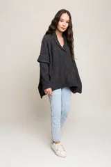 Poncho de lana merino color gris oscuro, con mangas largas ajustadas y cuerpo suelto.