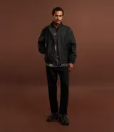 Pantalón de vestir negro de corte recto, con cintura elástica y trabillas, cierre tradicional y bolsillos laterales. Confeccionado en tejido de algodón y viscosa.