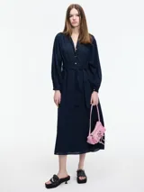 Vestido largo azul marino con escote en V, botones frontales y lazo ajustable en la cintura. Mangas largas con puños abotonados.