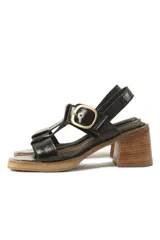 Sandalias de cuero color marrón con tiras anchas y hebilla plateada. Taco de madera.