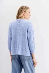 Cardigan de punto gris, corte relajado y mangas largas, con frente completamente cubierto de lentejuelas.