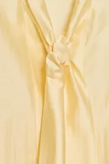 Camisa de corte holgado confeccionada en tejido satinado con mezcla de lyocell. Presenta cuello redondo con escote en pico y lazada frontal integrada. Cuenta con mangas largas abullonadas terminadas en puños anchos y bajo recto.