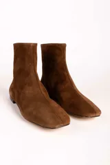 Botas de caña media confeccionadas en gamuza color marrón, con diseño de punta cuadrada y costura central vertical.