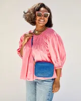 Bandolera rectangular azul de cuero tejido a mano, con correa larga al hombro.