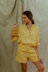 Campera tipo bomber de lino color amarillo, con cierre frontal metálico y mangas largas con puños elásticos.