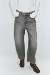 Jeans de tiro medio con diseño cropped, confeccionados en denim gris con efecto lavado. Presentan costuras laterales torcidas, trabillas para cinturón, cinco bolsillos y cierre frontal con cremallera y botón metálico.
