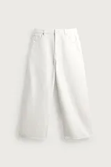 Jeans wide fit de corte relajado y tiro medio, confeccionados en denim de algodón color blanco. Diseño de cinco bolsillos y cierre frontal con cremallera y botón.