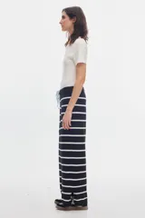 Pantalón de punto negro con rayas horizontales blancas, de calce recto y cintura elastizada.