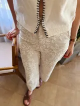 Pantalón de lino color beige con bordado floral blanco, corte recto y cintura elastizada en la parte trasera.