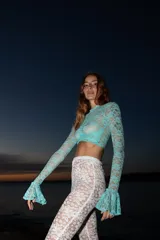 Top de encaje color aguamarina, de corte cropped y manga larga con puños acampanados.