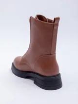 Bota de media caña color negro, con cierre frontal y suela de goma con plataforma.