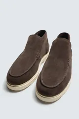 Bota casual de piel con acabado serraje color beige, con detalle de bordón en el empeine, horma redonda y suela a contraste.