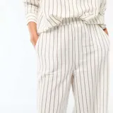 Pantalón palazzo de lino mezclado, color blanco con diseño de rayas verticales finas en color negro, de corte ancho y tiro alto con cintura elástica.