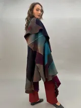 Capa de lana merino afieltrada, con diseño de espiral en tonos azul, marrón, gris y borgoña.