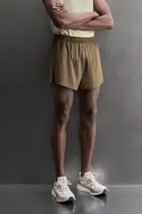 Short de running confeccionado en tejido técnico ligero y elástico con estructura. Cuenta con forro interior, cintura elástica ajustable con cordón, bolsillo trasero con cierre oculto, bolsillos laterales multifunción y aberturas laterales en las perneras.
