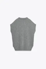 Chaleco oversize de lana color gris, con cuello redondo, manga sisa y bajo asimétrico con aberturas laterales.