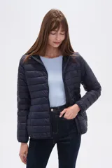 Campera acolchada tipo puffer, color beige claro, con capucha y cierre frontal. Presenta costuras horizontales y un calce entallado.