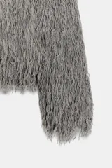 Chaqueta de cuello redondo y manga larga, confeccionada con textura de flecos en toda la prenda. Presenta cierre frontal con ganchos ocultos y un diseño corto.