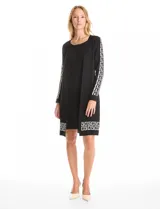 Vestido midi de tejido de punto con diseño integrado que simula un conjunto de vestido y cárdigan. Presenta escote redondo, manga larga y un estampado geométrico en blanco sobre fondo negro en las mangas y el ruedo.