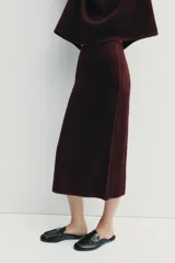 Falda midi de tiro alto confeccionada en tejido de punto con lana, de corte recto y cintura elástica.