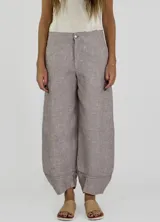 Pantalon de lino color beige, de corte recto y holgado, con cintura alta y ruedo con doblez.
