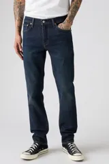 Jean de corte slim fit, color azul oscuro con efecto lavado sutil. Presenta cierre de botones y cinco bolsillos clásicos.