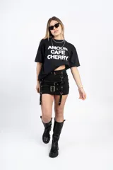 Minifalda negra con tres hileras de correas ajustables con hebillas plateadas.