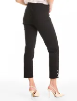 Pantalón de tiro alto con pretina elástica y silueta ajustada. Presenta un diseño tipo pull-on sin cierres, con aberturas laterales en el ruedo decoradas con tres botones metálicos dorados.