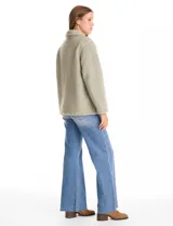 Sobrecamisa de tejido sherpa color verde oscuro, con cuello de solapa, cierre frontal con botones y bolsillos delanteros.